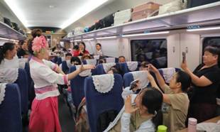 Stewardesses interact with passengers aboard train No. D86 from Kunming, capital city of southwest China's Yunnan Province, to the Lao capital Vientiane, July 18, 2025. (Photo by Yang Zixuan/Xinhua)
